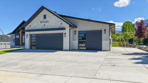 View of front of house featuring stone siding, a garage, and concrete driveway