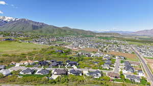 Aerial view of property and surrounding area with nearby suburban area and mountains