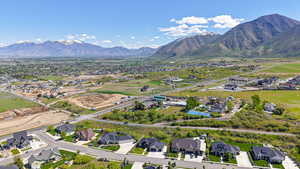 Aerial view of property and surrounding area featuring nearby suburban area and mountains