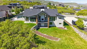 Back of property featuring stucco siding, a mountain view, a residential view, and roof with shingles