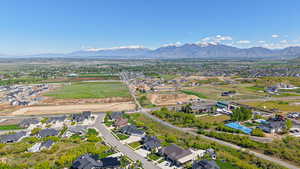 Aerial view of property and surrounding area with mountains and nearby suburban area