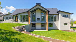 Rear view of property featuring stucco siding, a patio area, and a yard
