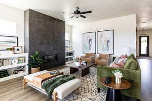 Living room with a fireplace, ceiling fan, hardwood / wood-style flooring  Photo of Finland Model Home not subject property