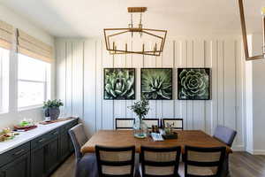 Dining space featuring a 10' long built in dining storage & buffet, a notable chandelier, and dark hardwood / wood-style flooring. Photo of Finland Model Home not subject property