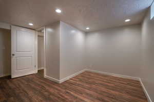 Empty room with dark wood-type flooring and a textured ceiling