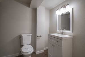 Bathroom featuring hardwood / wood-style floors, vanity, and toilet