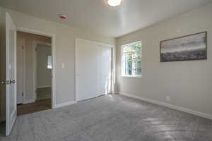 Unfurnished bedroom featuring a closet and carpet