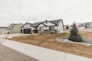 View of front of home with a front yard and a garage