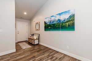 Entryway featuring vaulted ceiling and dark hardwood / wood-style floors