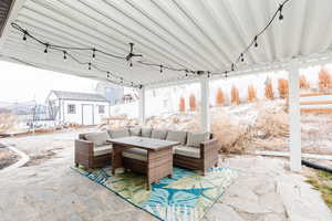 Snow covered patio featuring a trampoline, an outdoor living space, and a storage shed