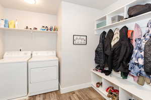 Laundry room with washer and dryer and light hardwood / wood-style flooring