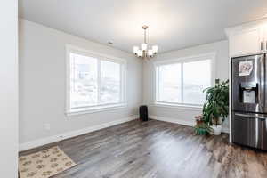 Dining space featuring an inviting chandelier and wood-type flooring