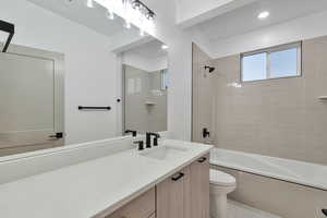 Full bathroom featuring toilet, vanity, tile patterned floors, and tiled shower / bath combo