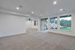 Unfurnished living room with ceiling fan and light carpet