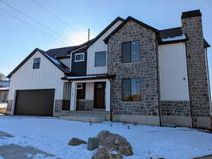 View of front of home featuring a garage and a porch