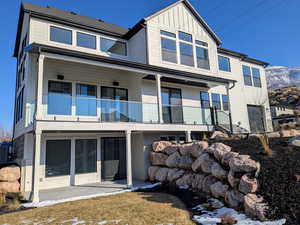 Back of property featuring a patio area, a balcony, and a mountain view