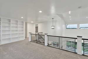 Interior space featuring carpet, a chandelier, and built in shelves