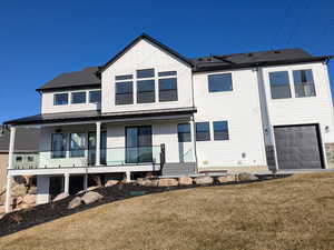 Rear view of property featuring a garage and a yard