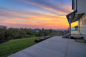 Patio terrace at summer dusk featuring a lawn