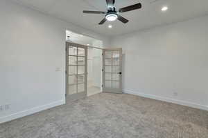 Spare room featuring french doors, ceiling fan, and light colored carpet