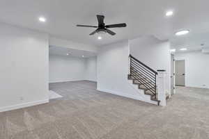 Interior space with light colored carpet and ceiling fan