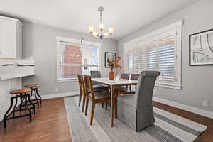 Dining room featuring dark hardwood / wood-style floors and an inviting chandelier