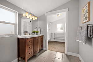 Bathroom with vanity and lofted ceiling