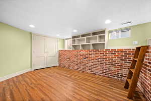 Interior space featuring hardwood / wood-style floors and brick wall