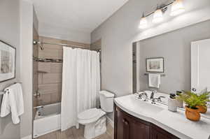 Full bathroom with vanity, toilet, and shower / bath combo with shower curtain