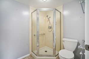 Bathroom with toilet and a shower with shower door