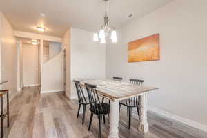 Dining room featuring an inviting chandelier and hardwood / wood-style flooring