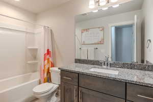 Full bathroom featuring shower / tub combo, vanity, and toilet