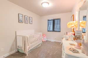 Carpeted bedroom featuring a crib