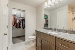 Master Bathroom featuring toilet, vanity, and tile patterned flooring