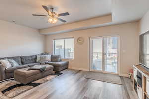 Living room featuring ceiling fan and light hardwood / wood-style flooring