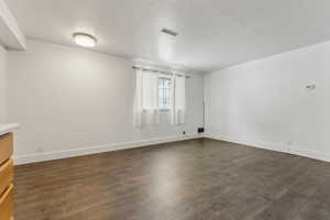 Empty room featuring dark hardwood / wood-style flooring