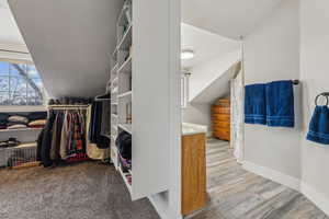 Spacious closet with light hardwood / wood-style flooring