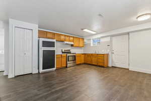 Kitchen featuring refrigerator, dark hardwood / wood-style flooring, electric stove, and sink