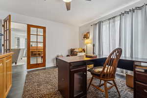 Home office featuring french doors, dark hardwood / wood-style floors, and ceiling fan