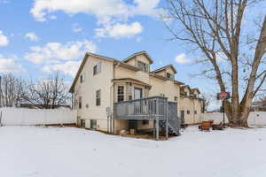 Snow covered back of property with a deck and central air condition unit