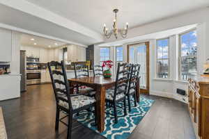 Dining room featuring dark wood-type flooring and an inviting chandelier