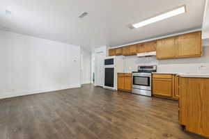 Kitchen featuring paneled fridge, stainless steel electric range, dark hardwood / wood-style floors, and sink