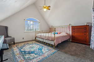 Carpeted bedroom with ceiling fan and lofted ceiling