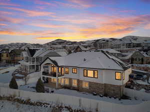 Snow covered rear of property with a mountain view