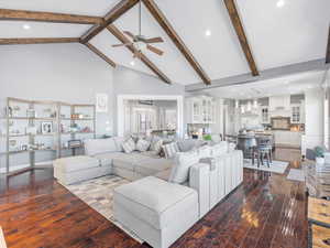 Living room featuring beamed ceiling, dark hardwood / wood-style flooring, and high vaulted ceiling