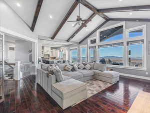 Living room featuring ceiling fan, beamed ceiling, and high vaulted ceiling