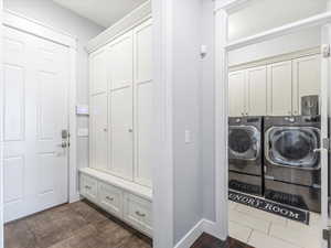 Washroom featuring separate washer and dryer and cabinets