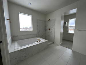 Bathroom featuring independent shower and bath and tile patterned flooring