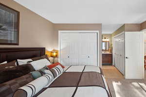 Tiled bedroom featuring connected bathroom and multiple closets