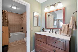 Full bathroom featuring toilet, vanity, tile patterned flooring, and shower / bathtub combination with curtain